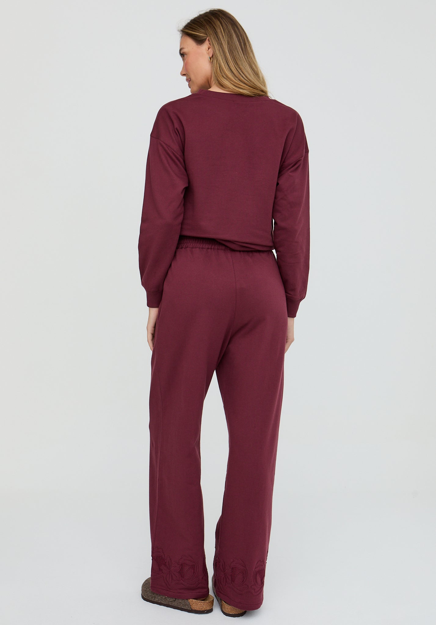 Person wearing a burgundy outfit on a white background