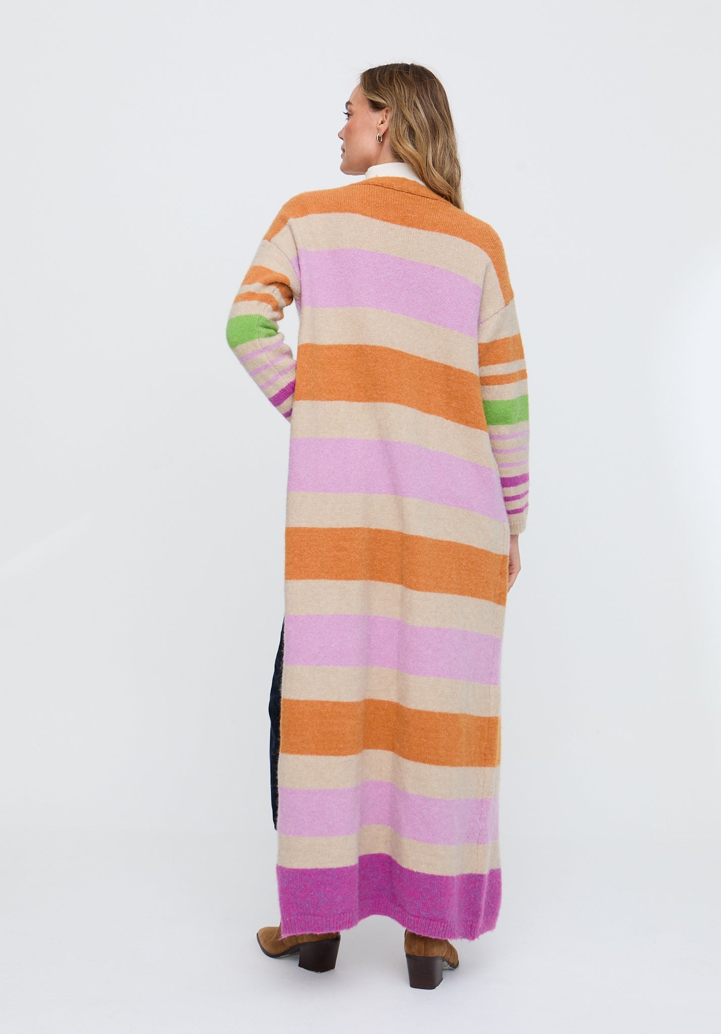 Woman wearing a long, colorful striped cardigan on a white background