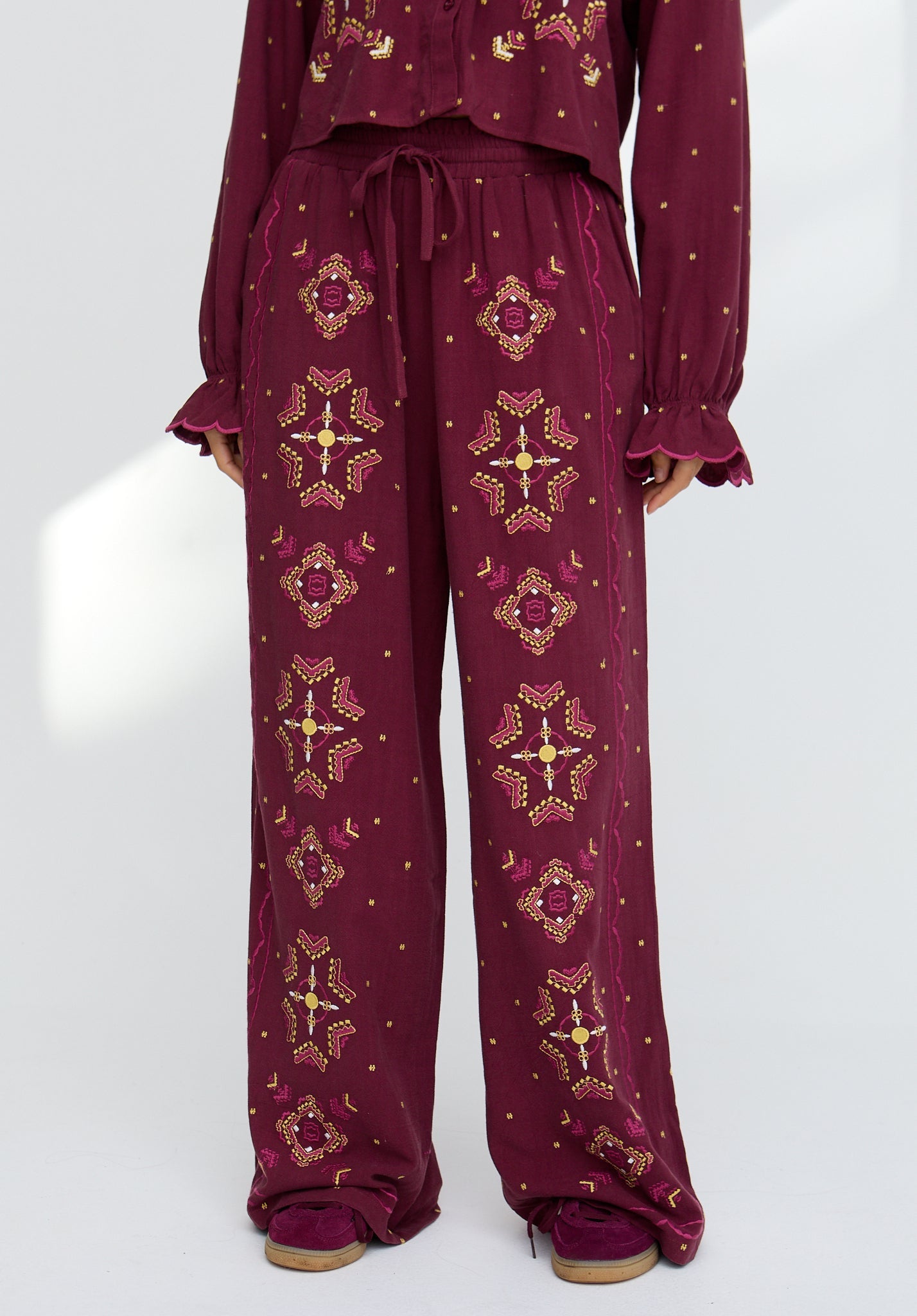 Maroon outfit with gold star patterns on a white background