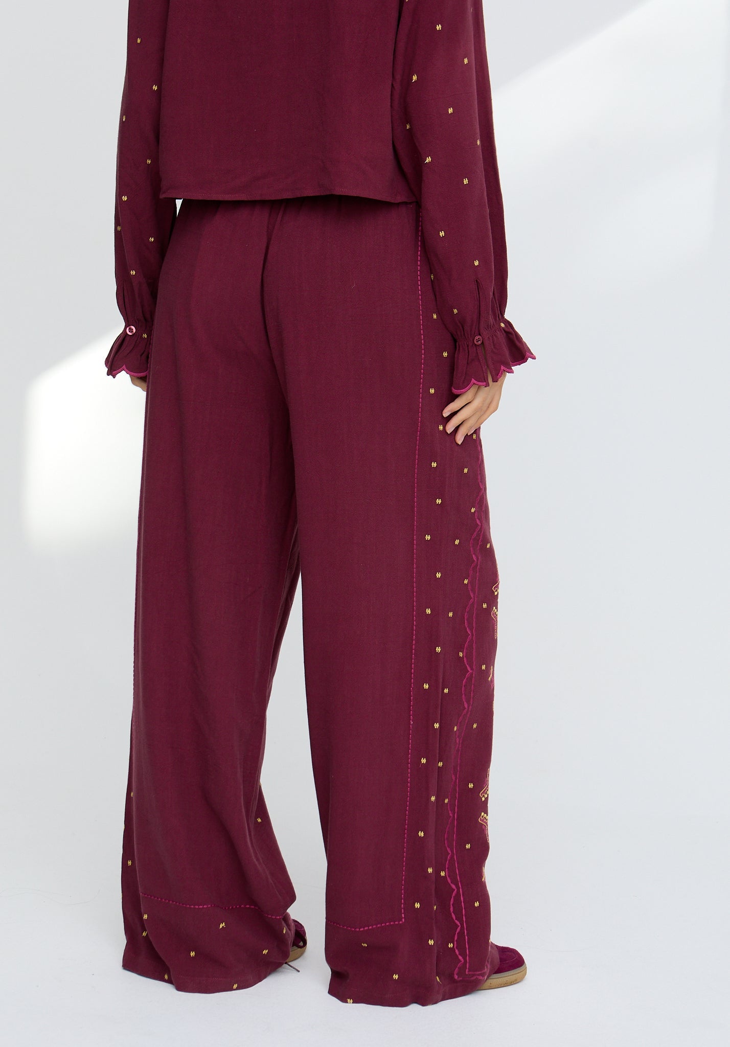Maroon outfit with gold embellishments on a white background
