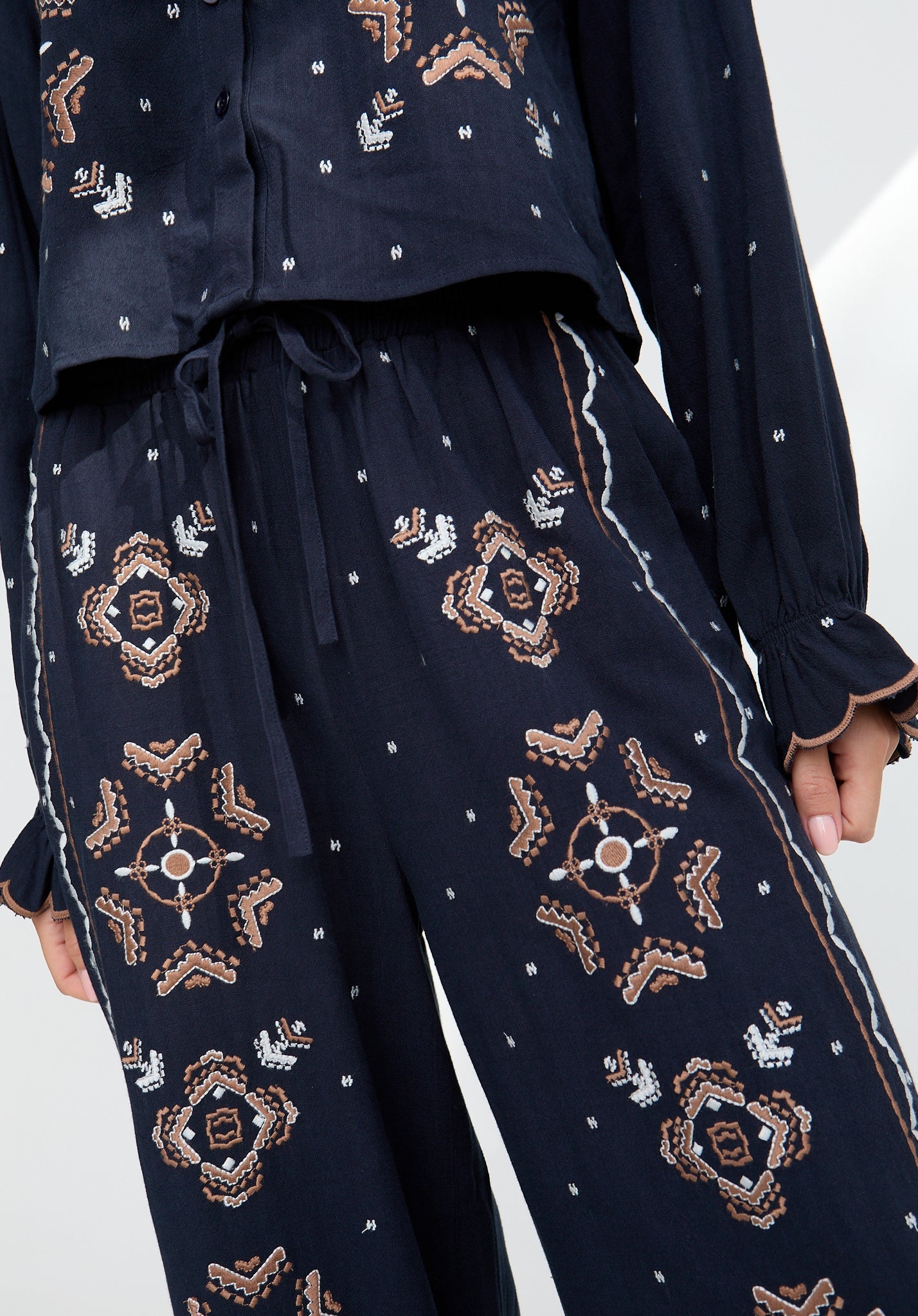 Navy blue outfit with intricate gold patterns on a white background