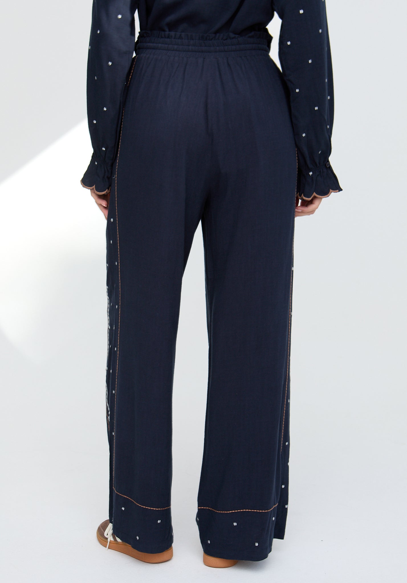 Navy blue outfit with decorative elements on a white background