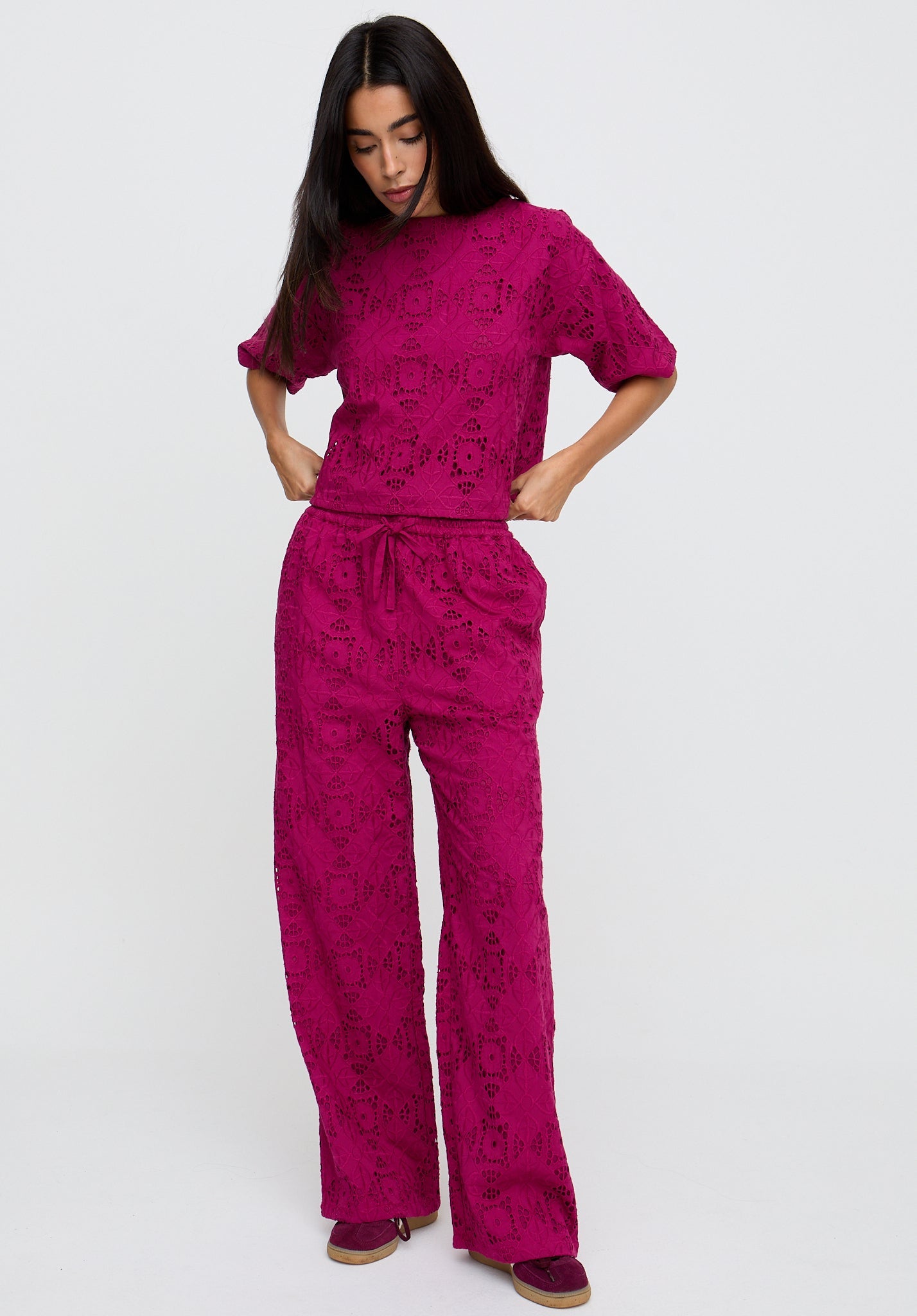 Woman wearing a pink patterned outfit on a white background