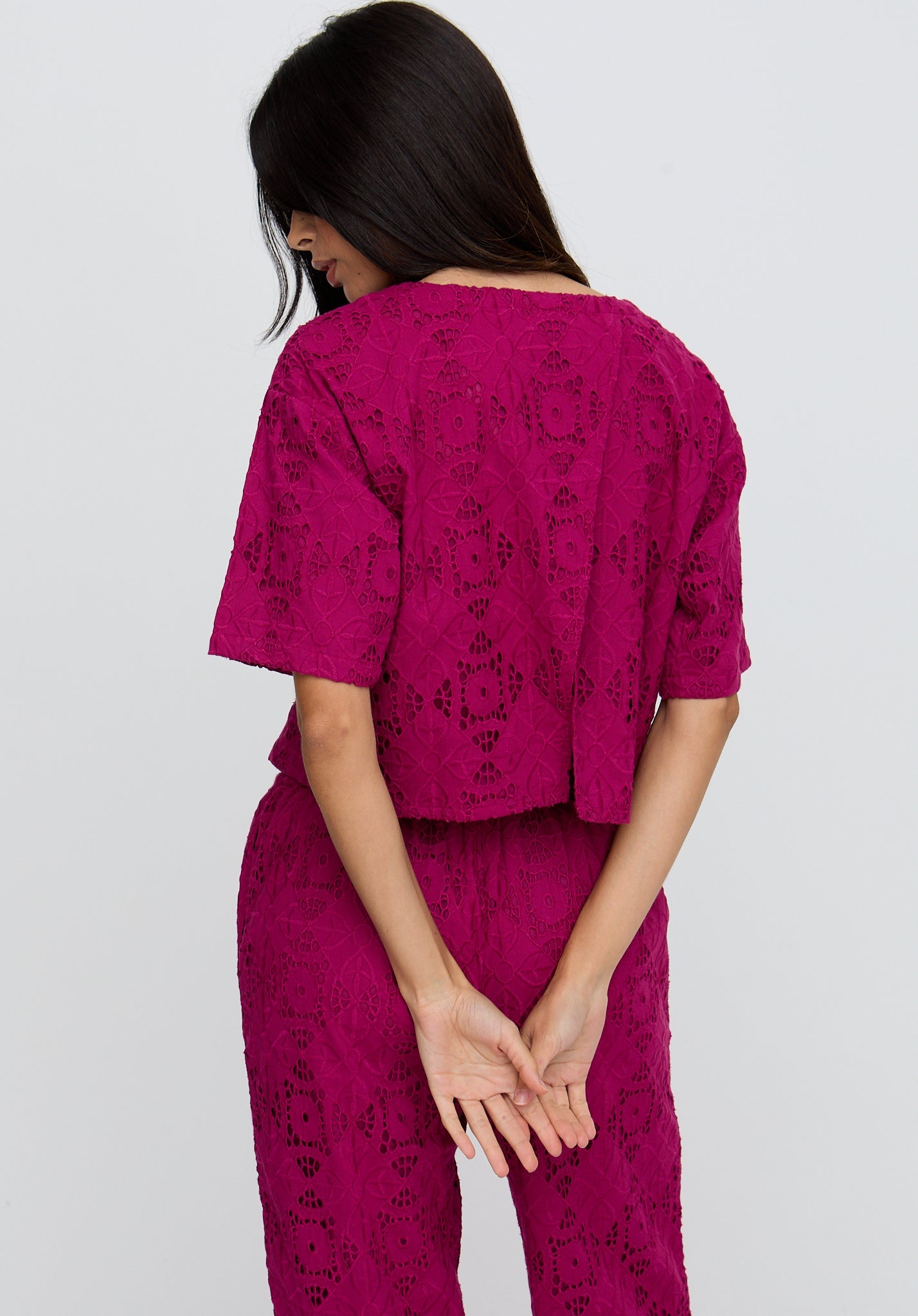 Woman wearing a pink patterned outfit on a white background