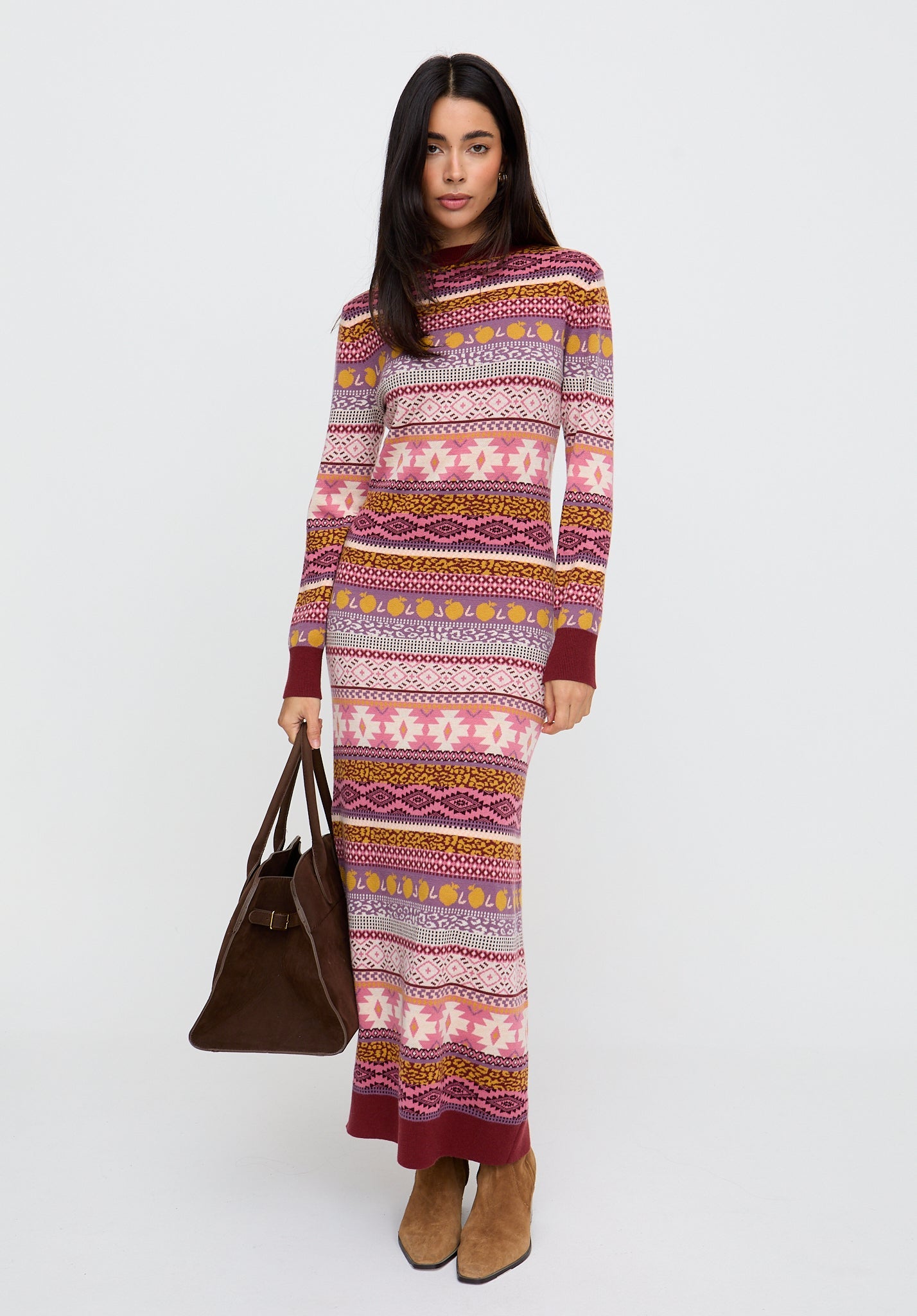 Woman wearing a long, patterned dress with a white background