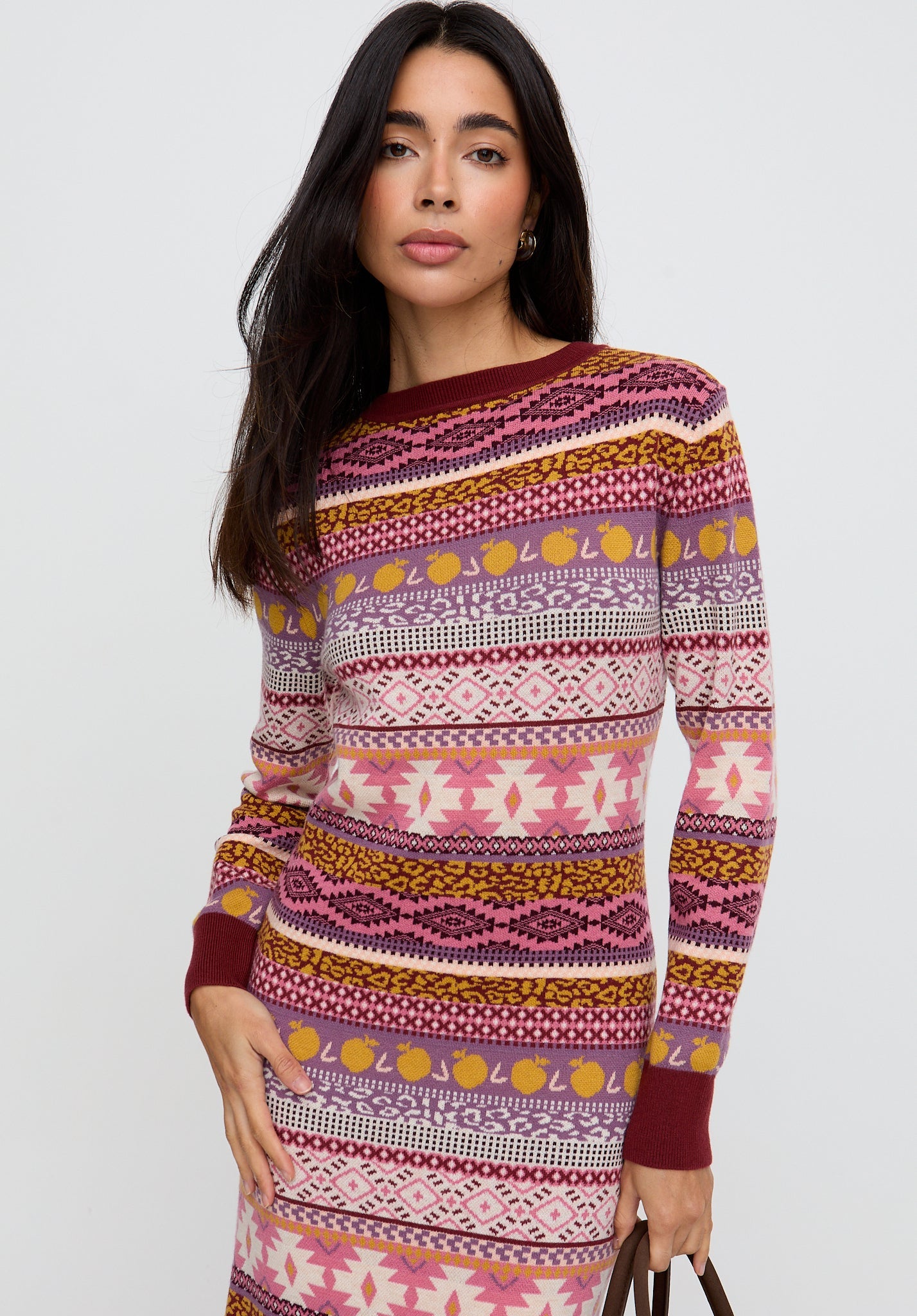 Woman wearing a colorful patterned sweater dress on a white background