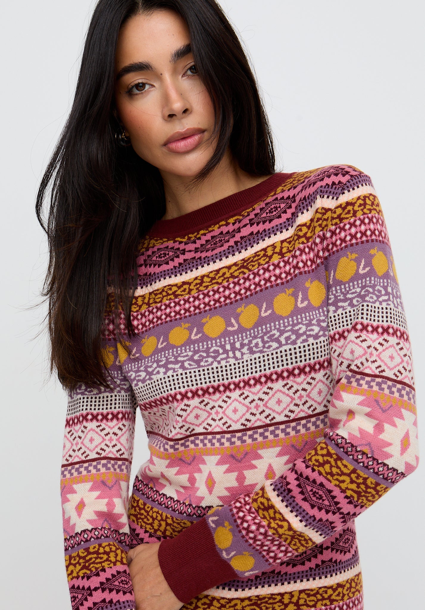 Woman wearing a colorful patterned sweater on a white background