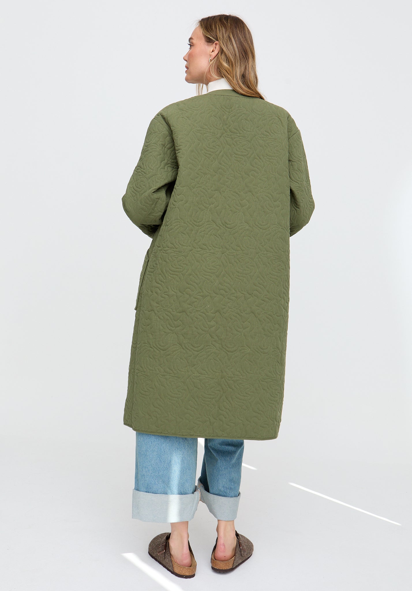 Woman wearing a green coat on a white background