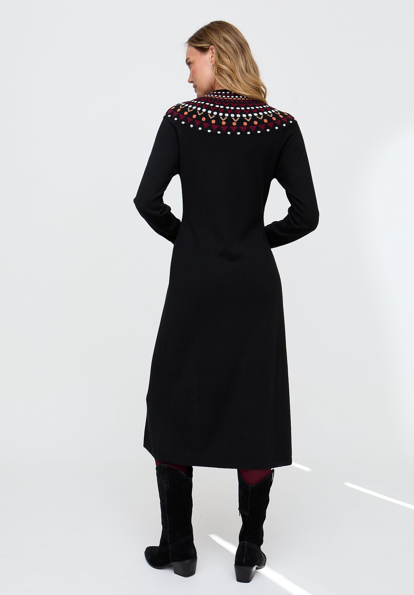 Woman wearing a black dress with colorful embroidery on a white background