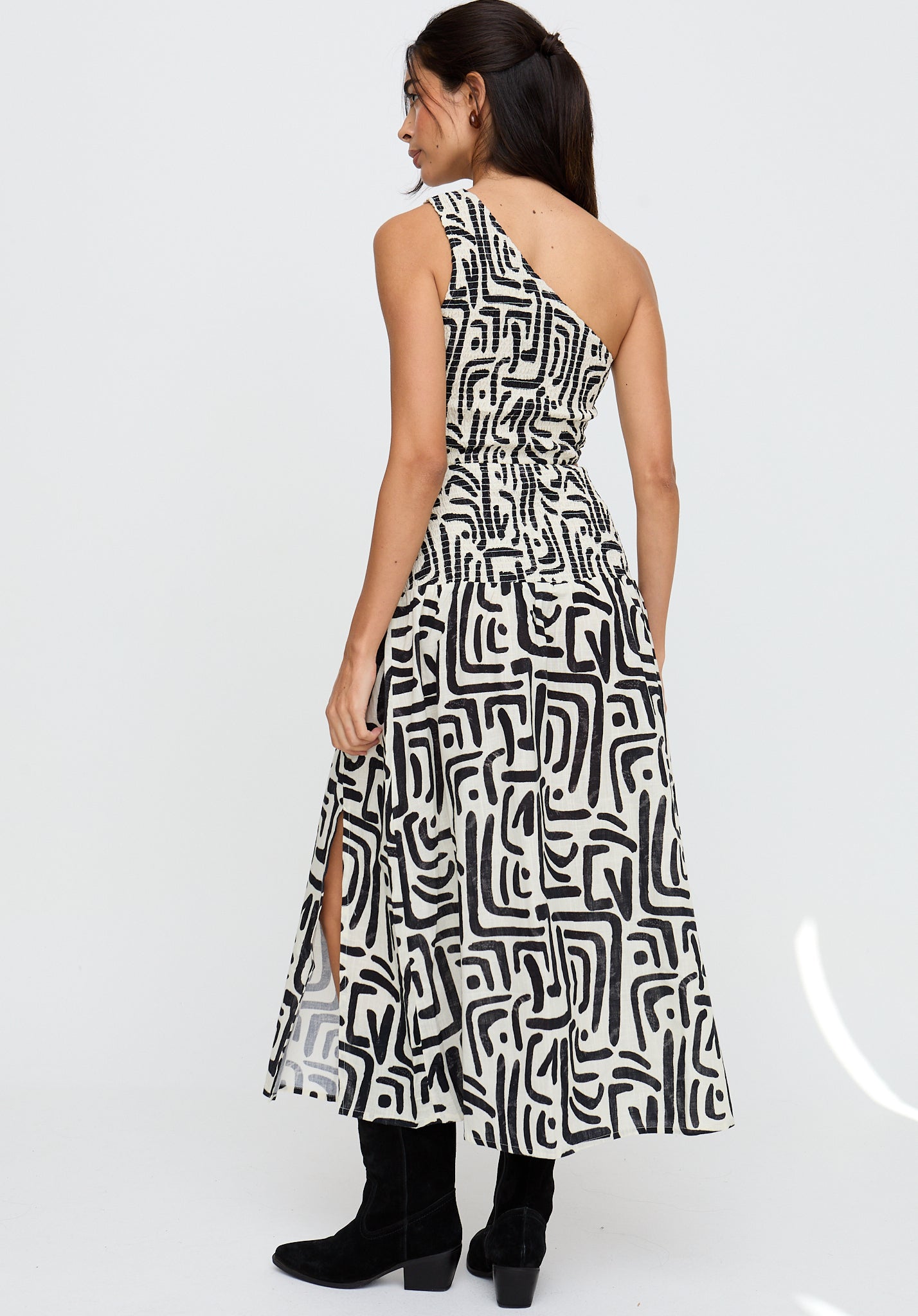 Woman wearing a black and white patterned dress on a white background