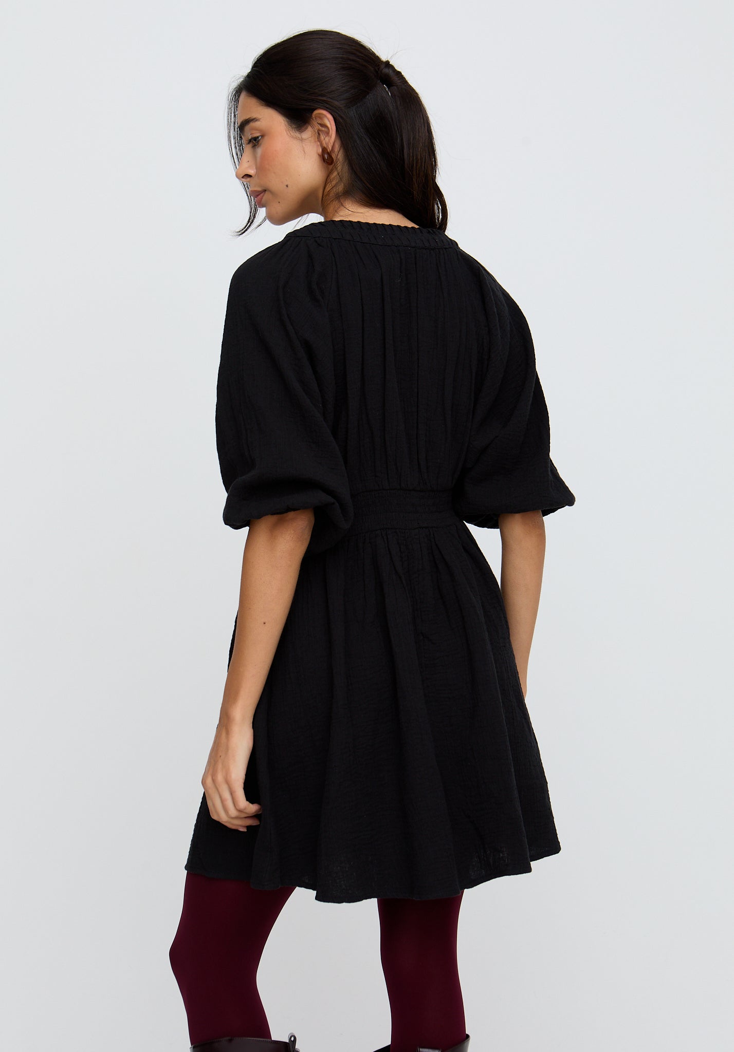 Woman wearing a black dress with a plain background