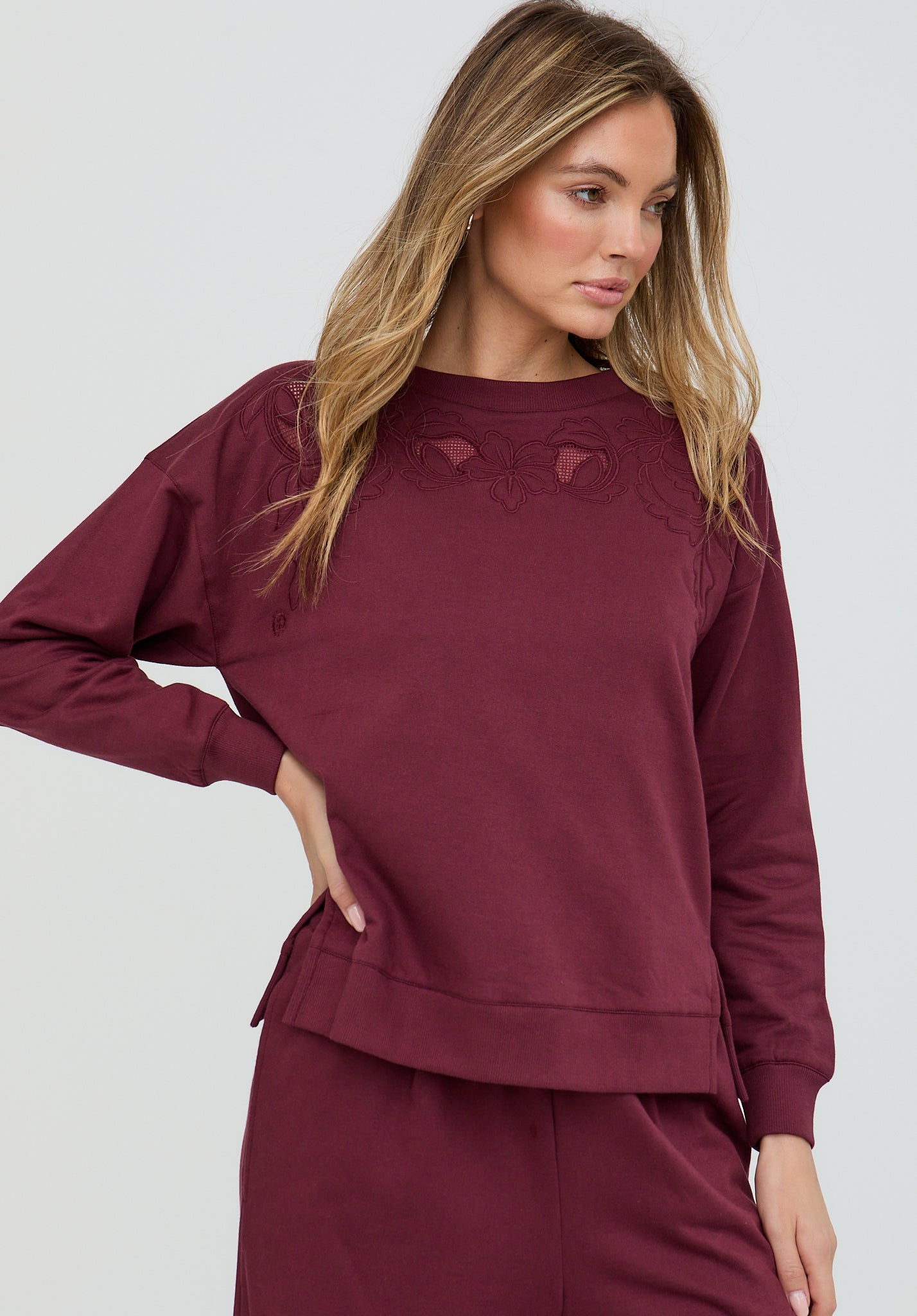 Woman wearing a burgundy outfit with a plain background