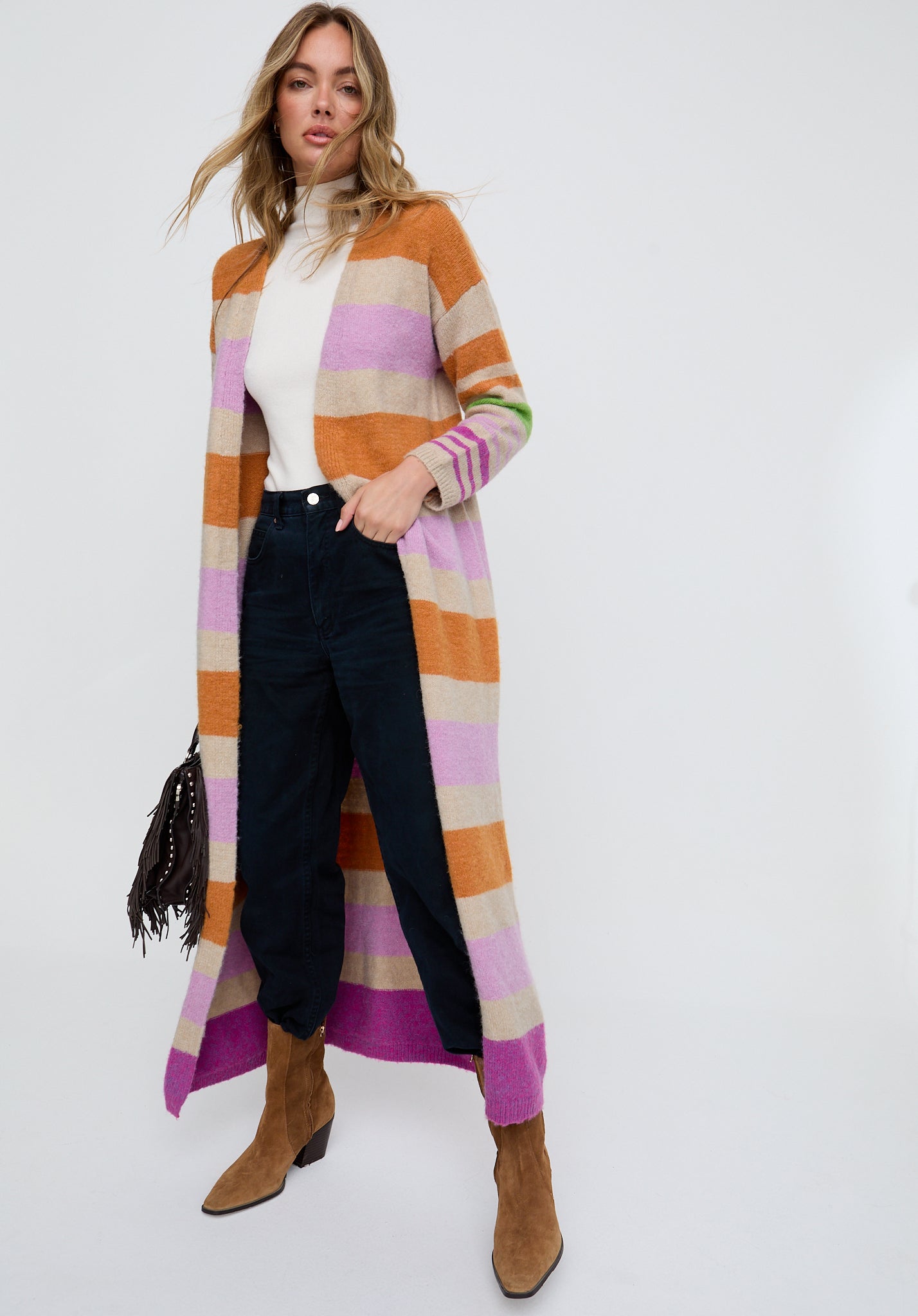 Woman wearing a long, colorful striped cardigan on a white background
