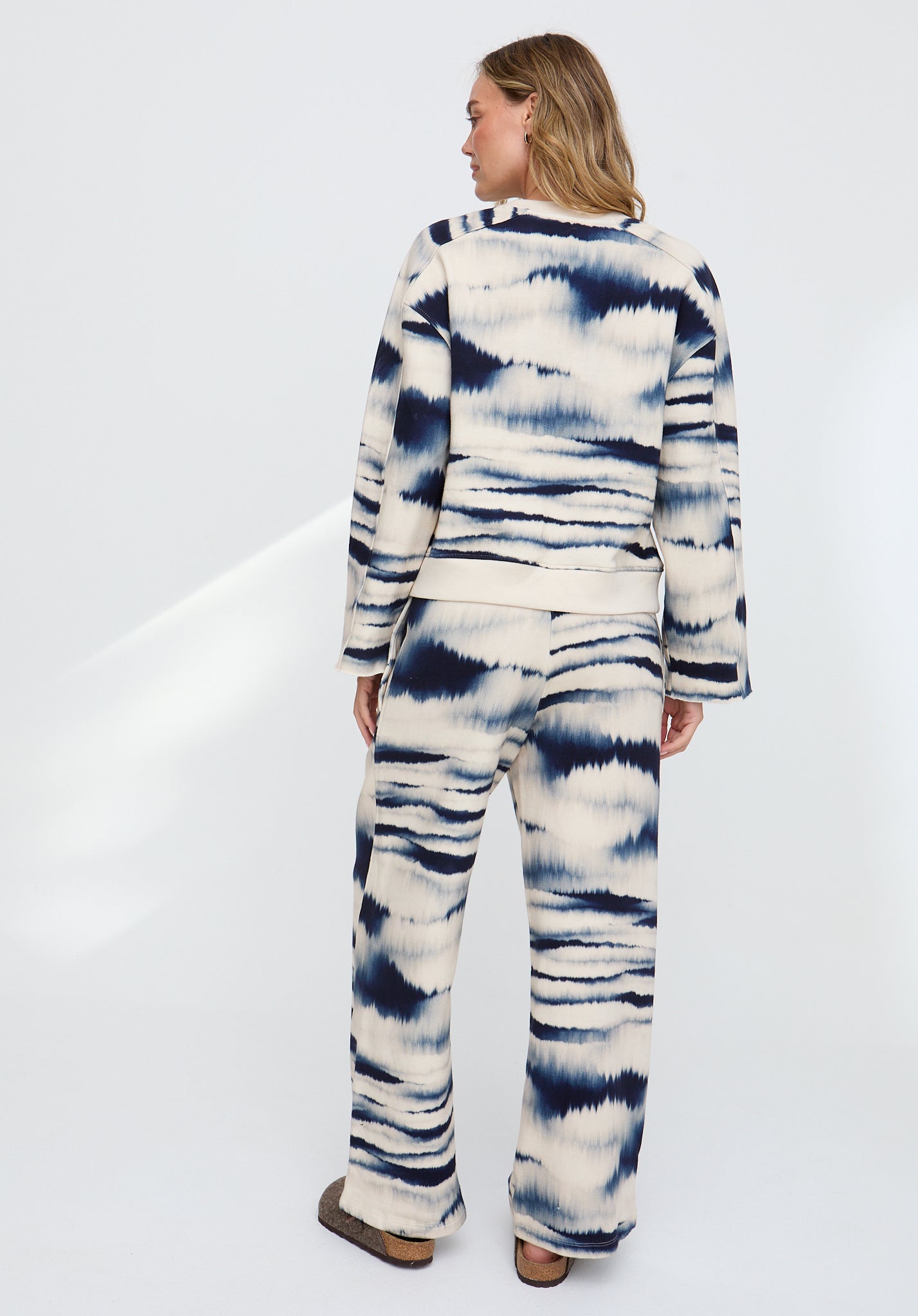 Person wearing a tie-dye outfit on a white background