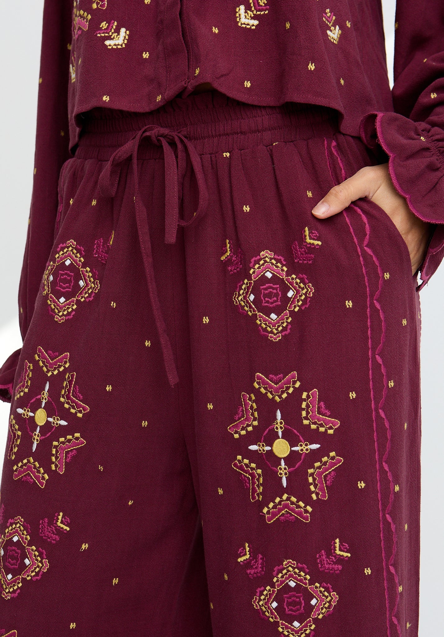 Maroon outfit with gold embroidery on a white background