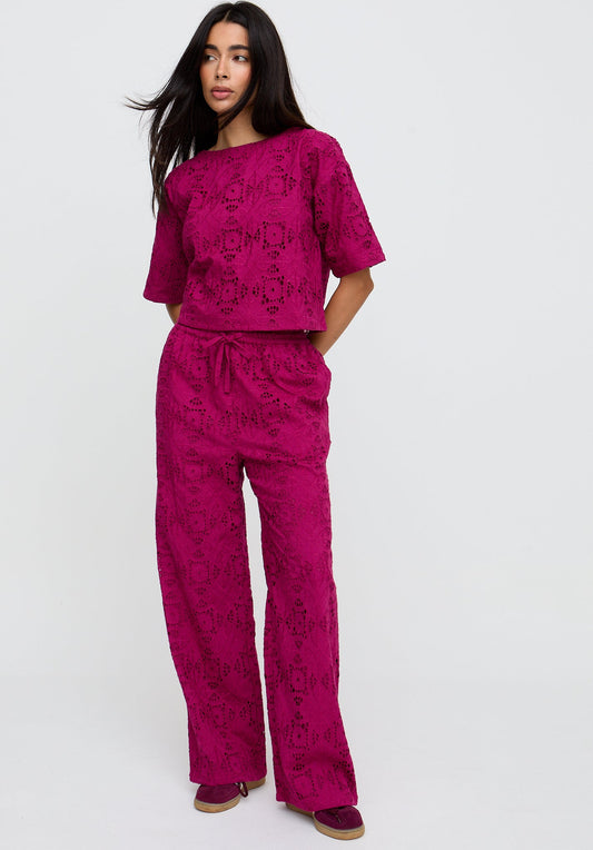 Woman wearing a pink patterned outfit on a white background