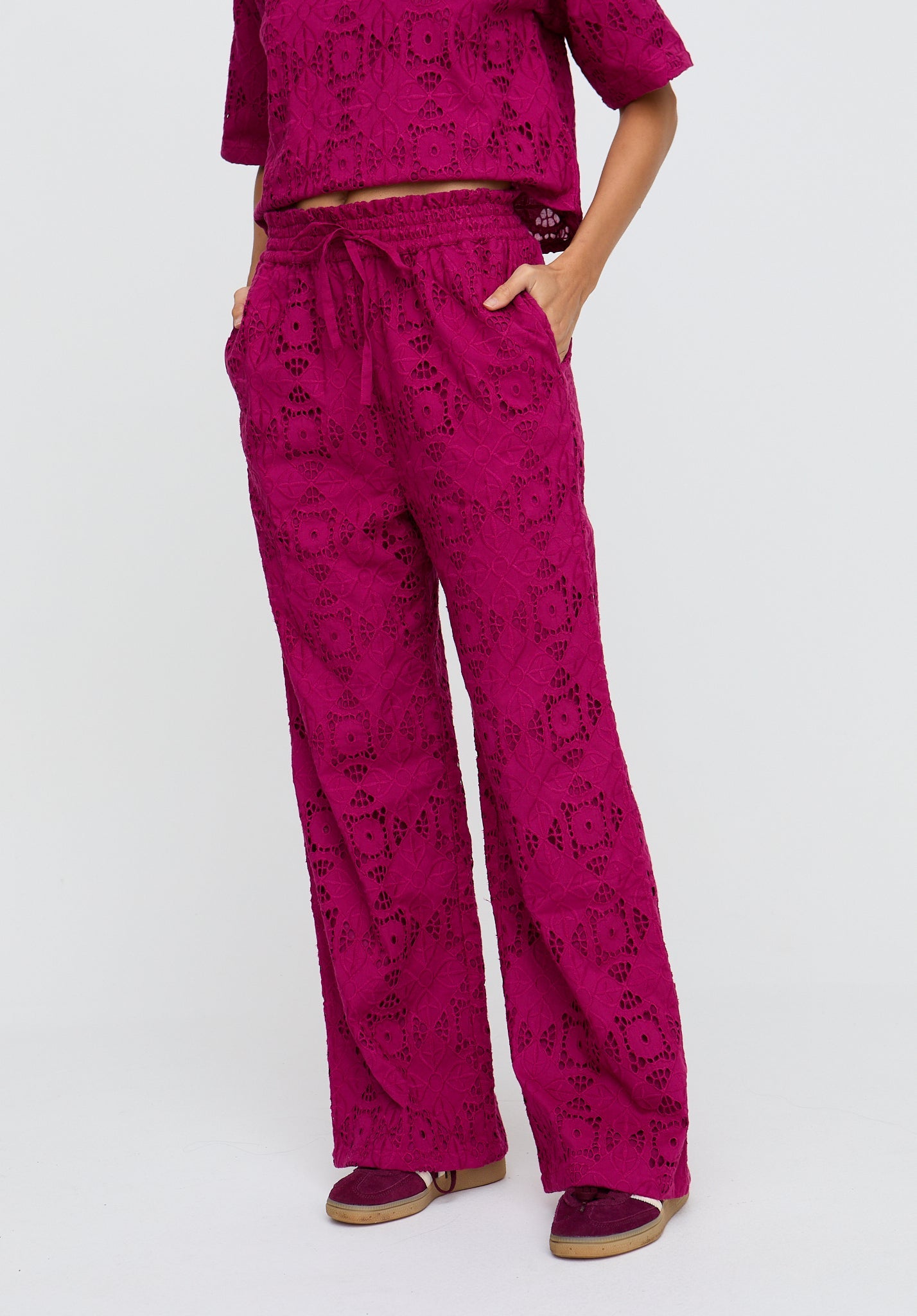 Person wearing a pink patterned outfit on a white background