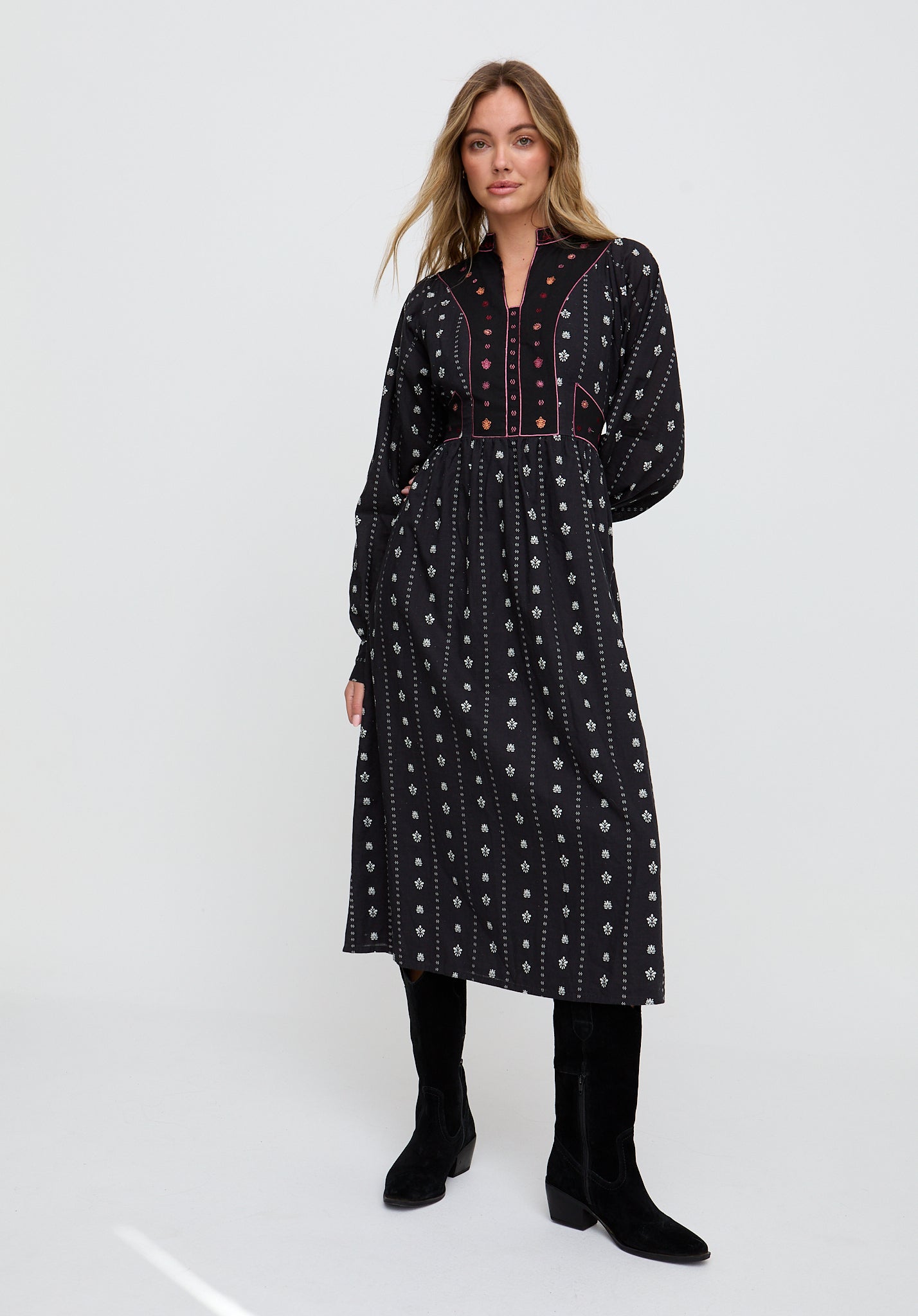 Woman wearing a black patterned dress on a white background