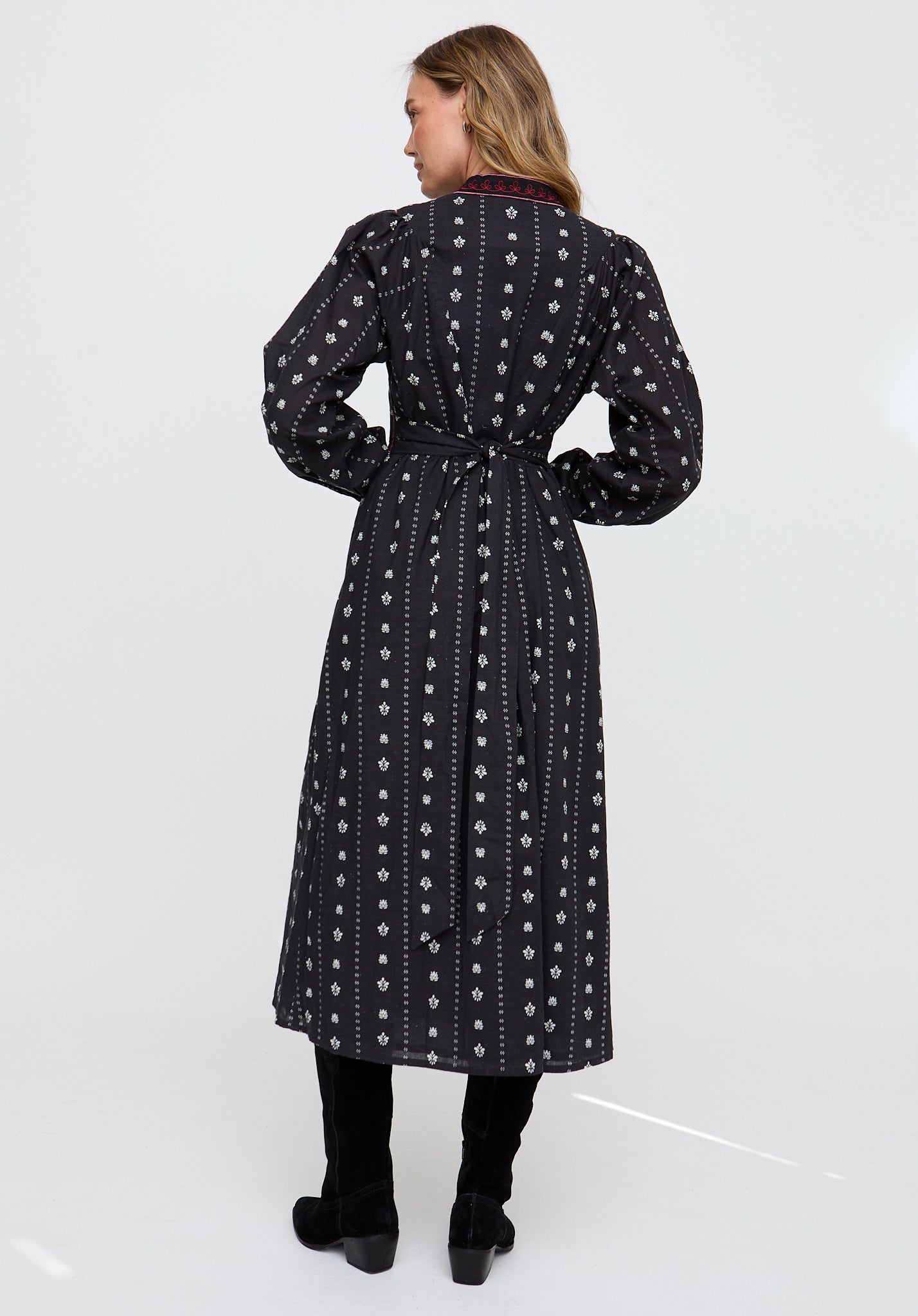 Woman wearing a black patterned dress on a white background