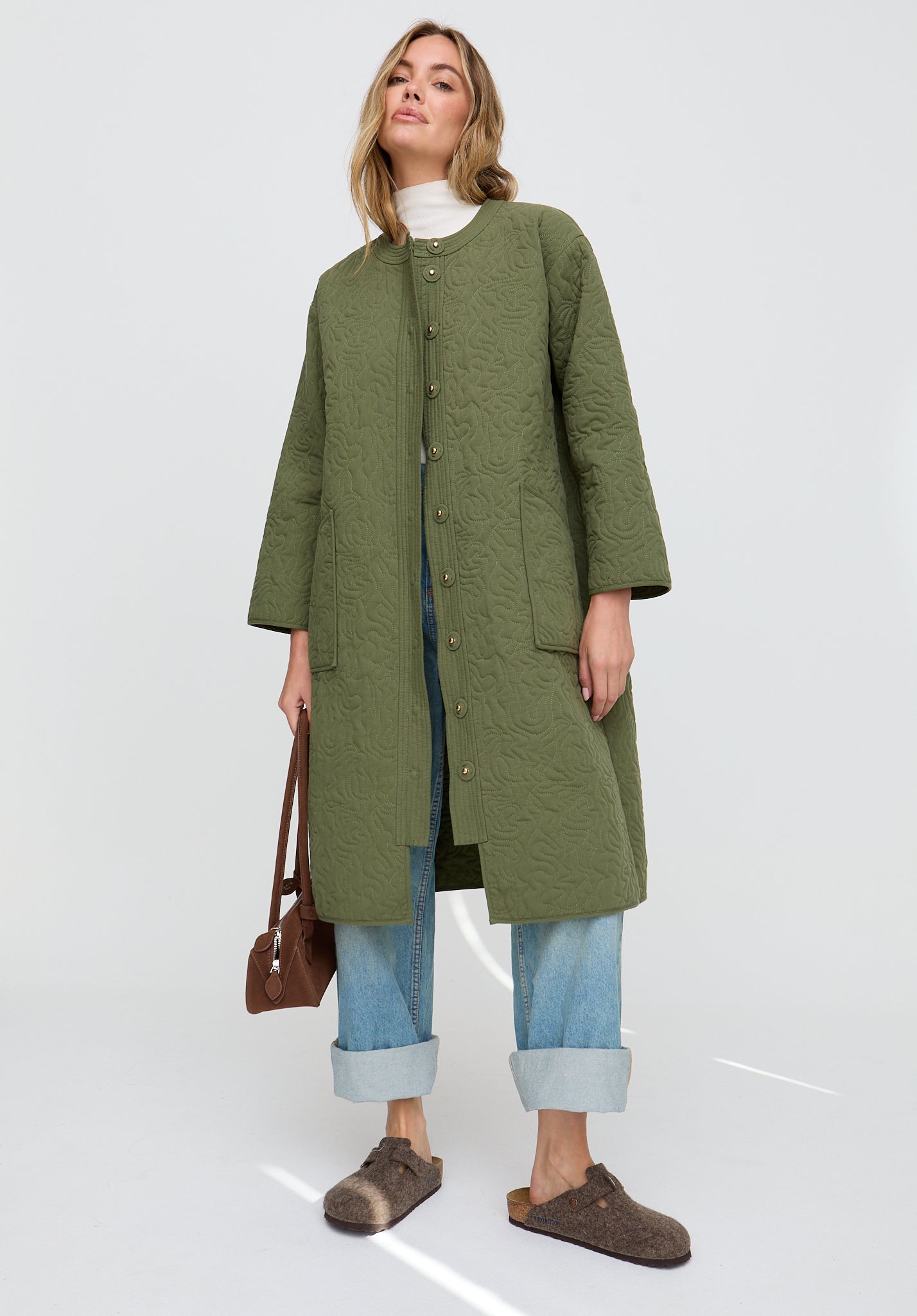 Woman wearing a green coat on a white background