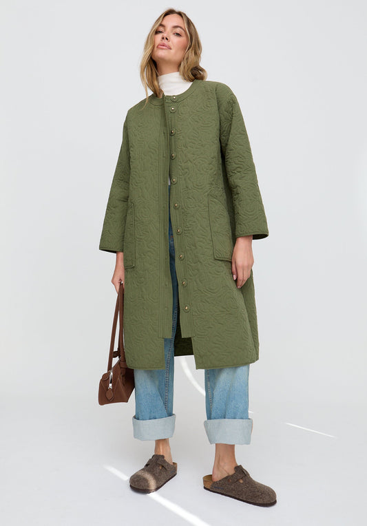 Woman wearing a green coat on a white background