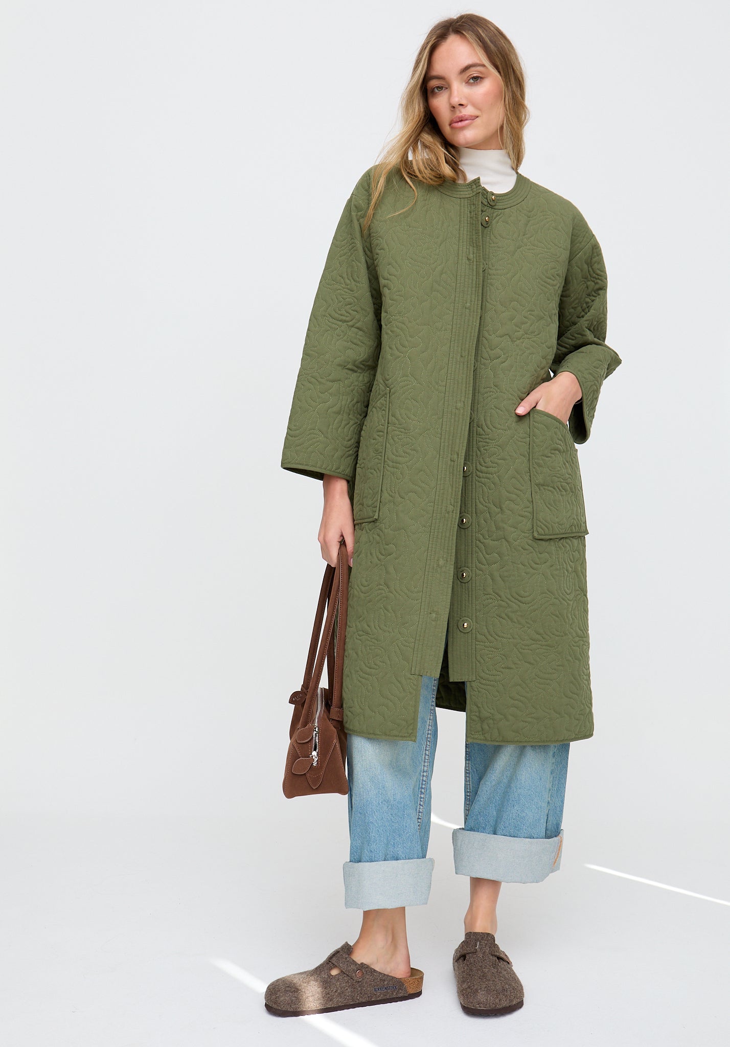 Woman wearing a green coat with a white background