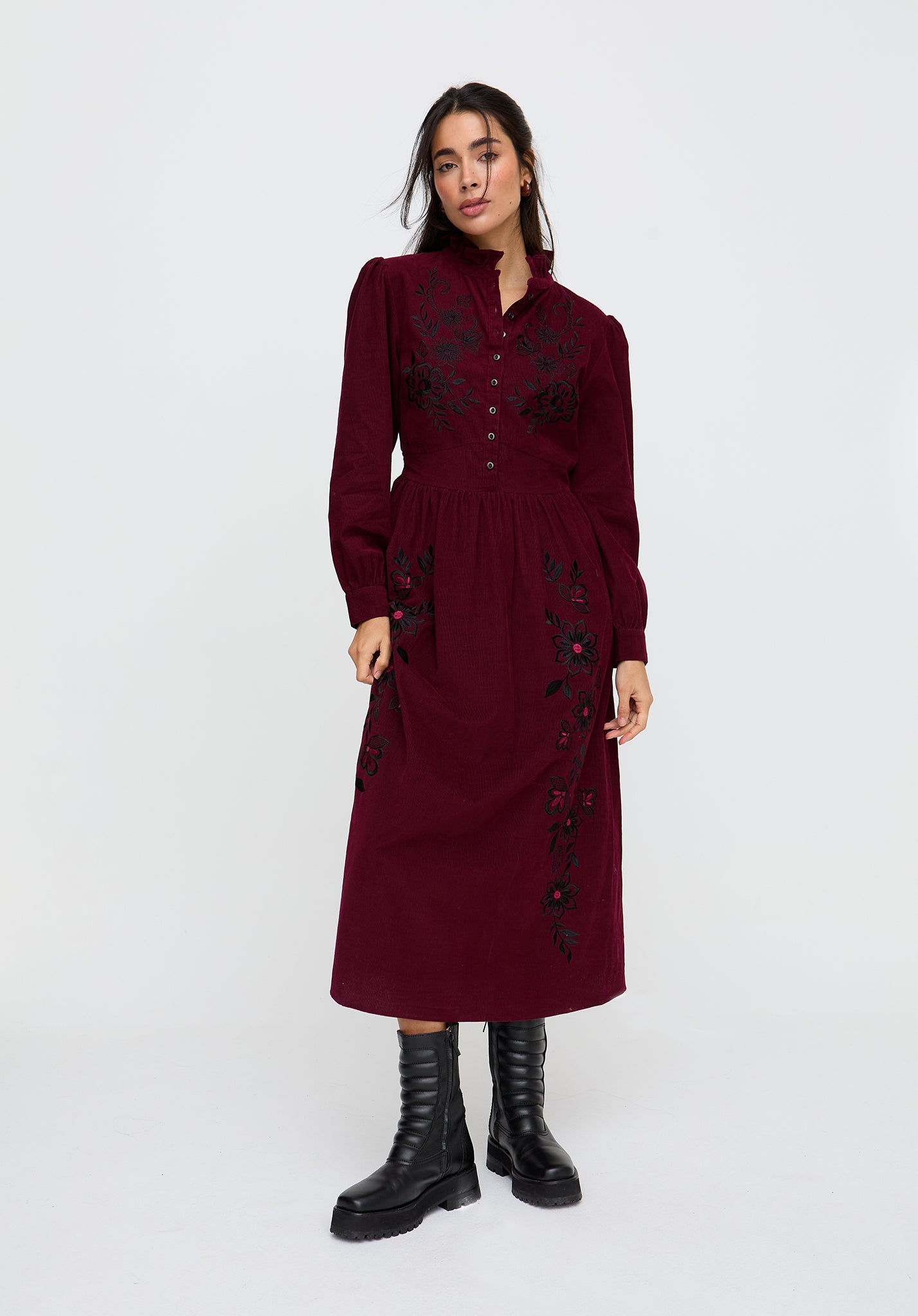 Woman wearing a burgundy dress with black patterns on a white background