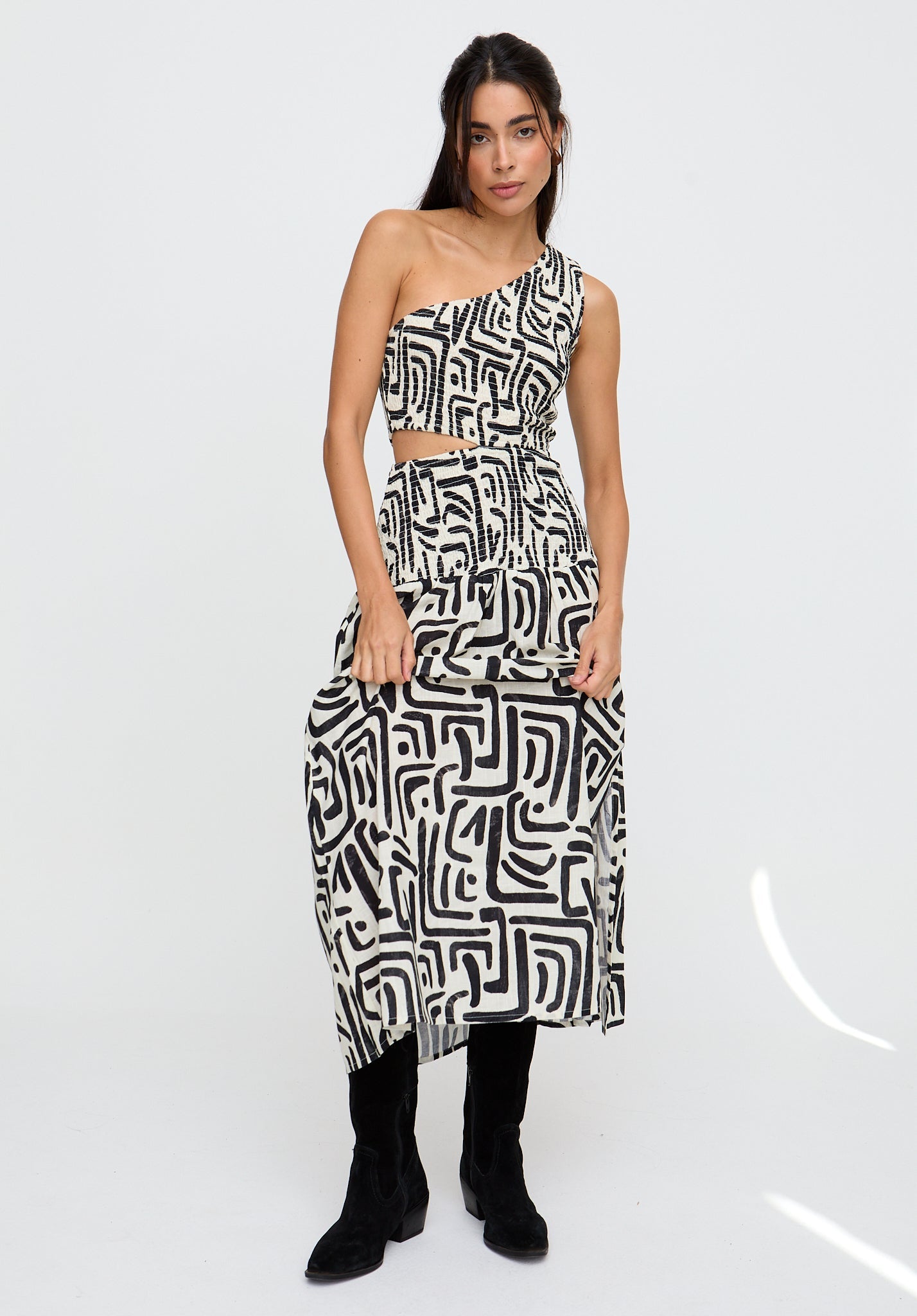 Woman wearing a black and white patterned dress on a white background