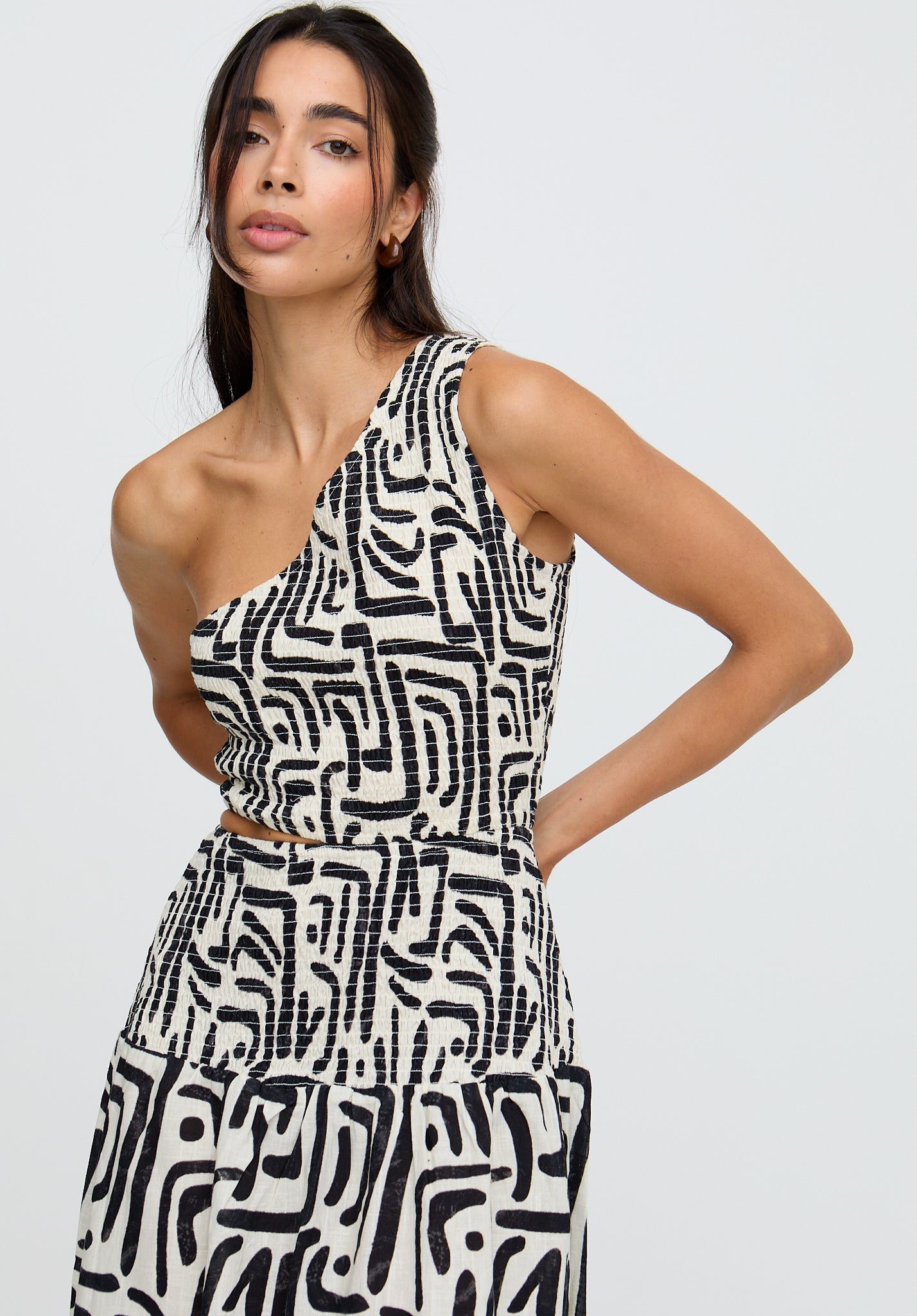 Woman wearing a black and white patterned dress against a plain background
