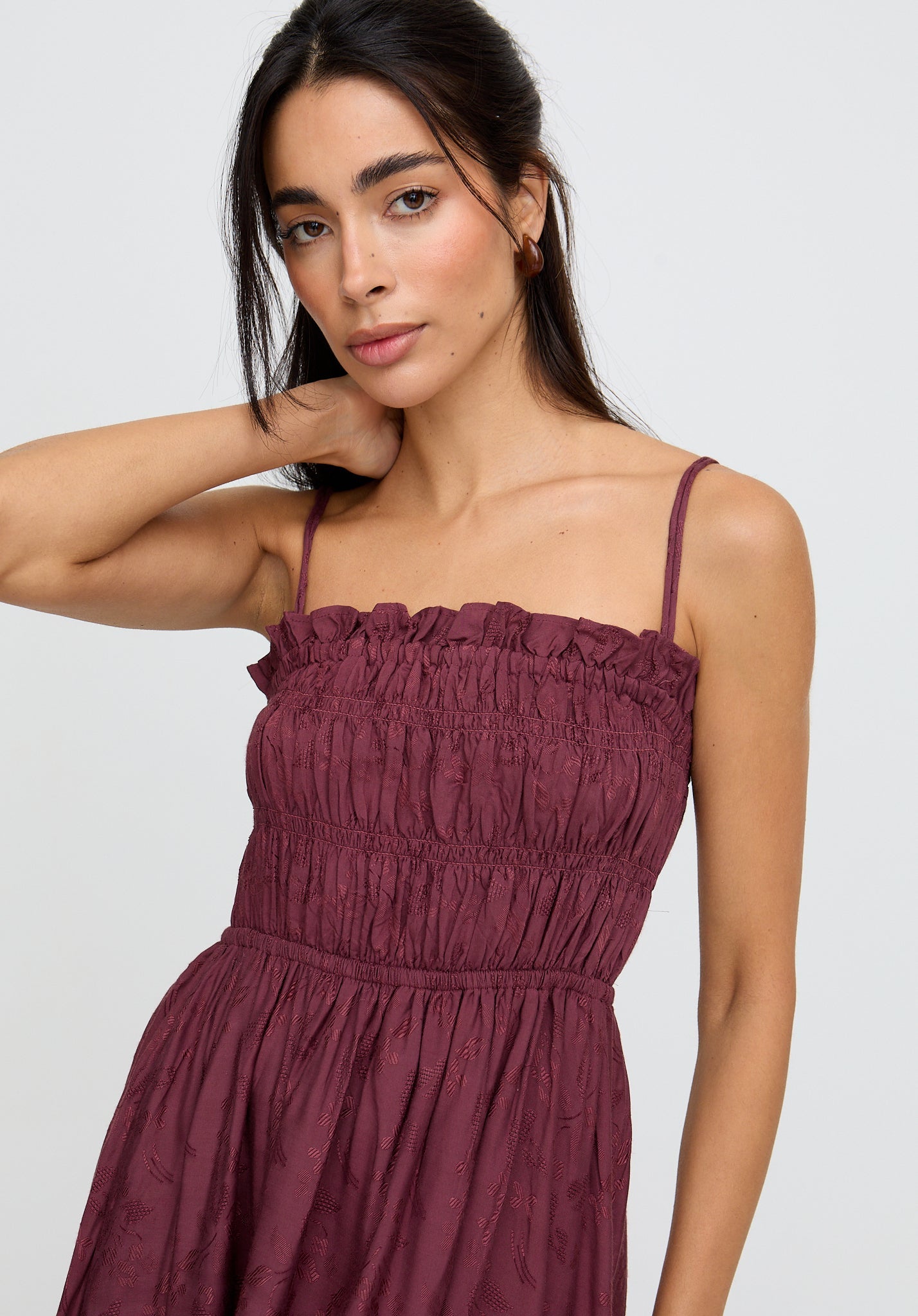 Woman wearing a burgundy dress against a white background