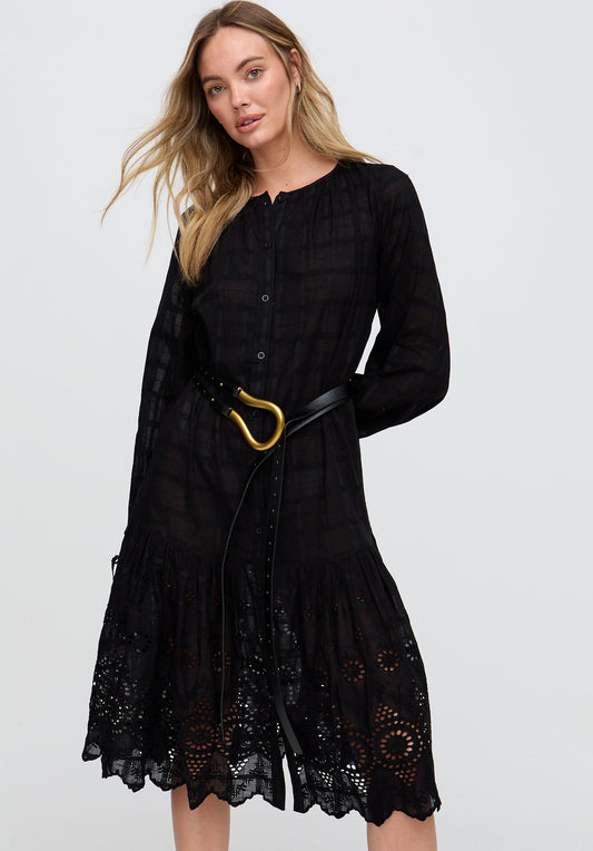 Woman wearing a black dress with lace details and a gold belt on a white background